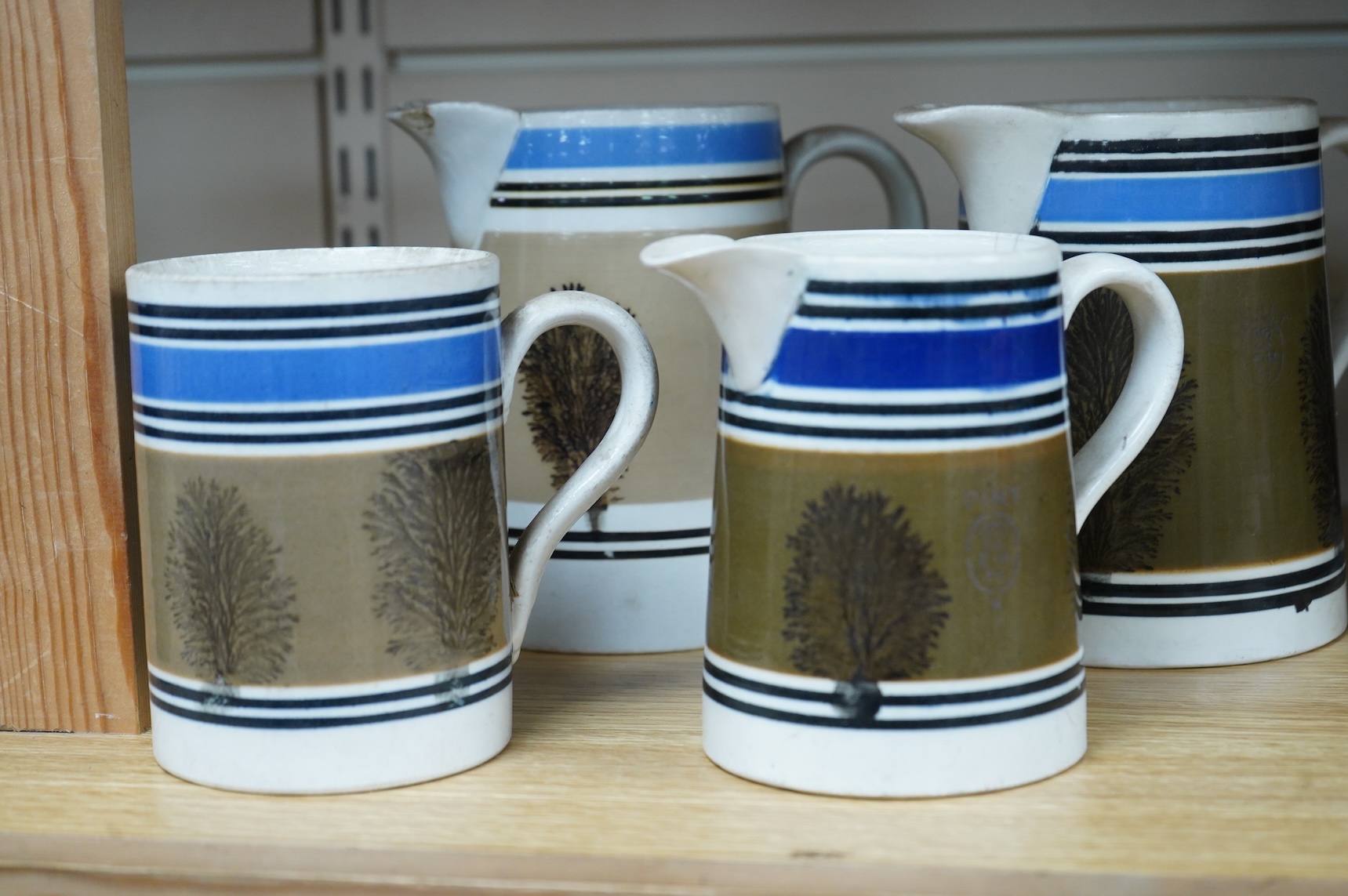 Three early 19th century Mocha ware jugs and a mug, largest 16cm high